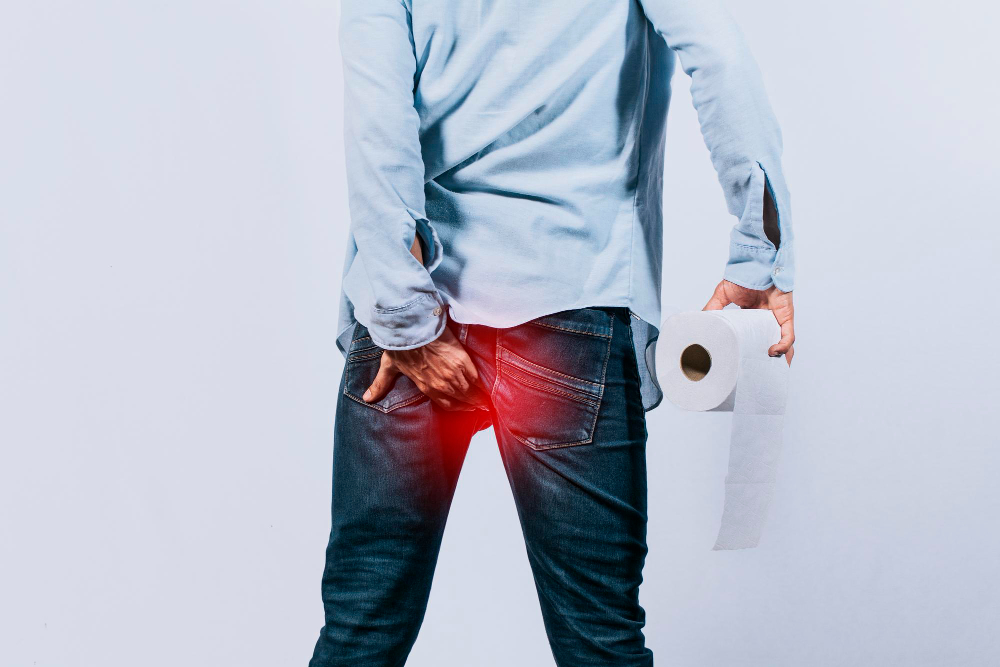 Mężczyzna z papierem toaletowym w dłoni dotykającym jego pośladka